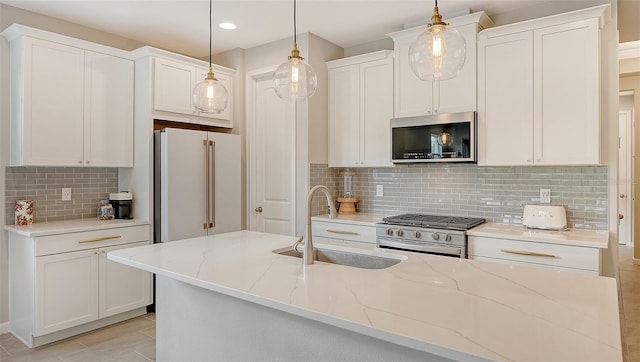 kitchen featuring decorative light fixtures, light stone counters, high end appliances, and white cabinets