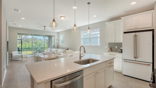 kitchen with a center island with sink, sink, stainless steel dishwasher, white cabinets, and white fridge