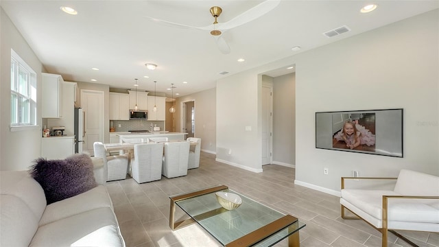 living room featuring ceiling fan and sink