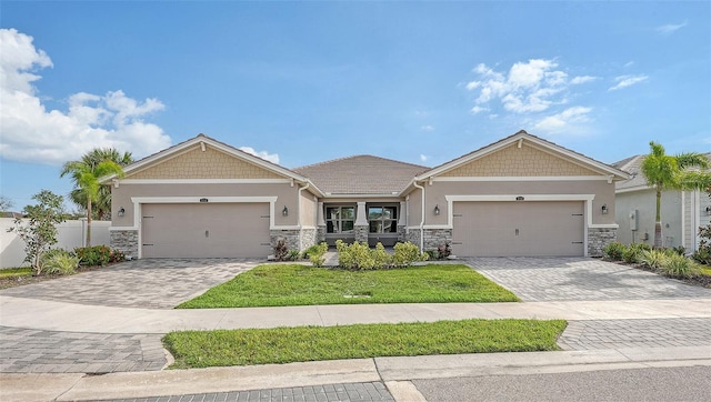 craftsman-style home featuring a front lawn and a garage