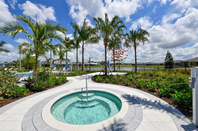 view of swimming pool with a community hot tub and a water view