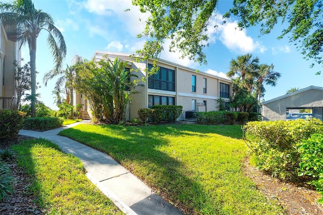 view of front of property featuring a front yard and central AC unit