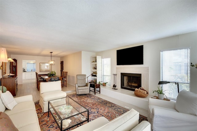 living room with a textured ceiling and a premium fireplace