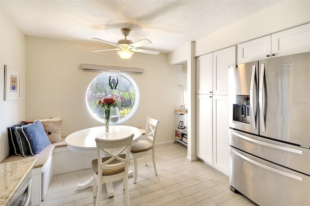 dining area with ceiling fan and a textured ceiling