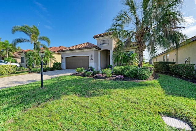 mediterranean / spanish-style home featuring a front lawn and a garage