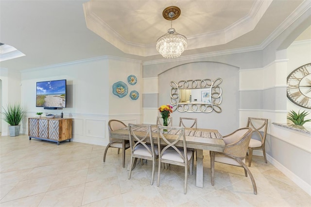 dining space with a chandelier, ornamental molding, and a tray ceiling