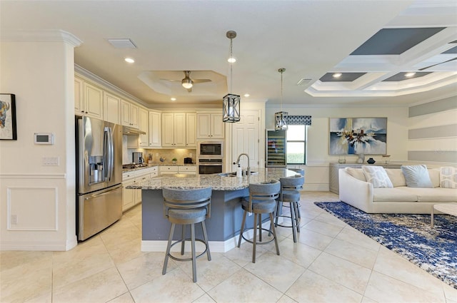 kitchen featuring pendant lighting, a kitchen breakfast bar, light stone countertops, ornamental molding, and appliances with stainless steel finishes