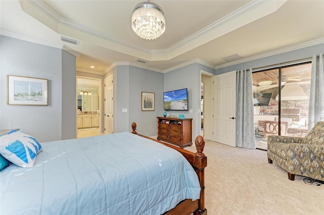 carpeted bedroom featuring a raised ceiling, connected bathroom, a chandelier, and ornamental molding