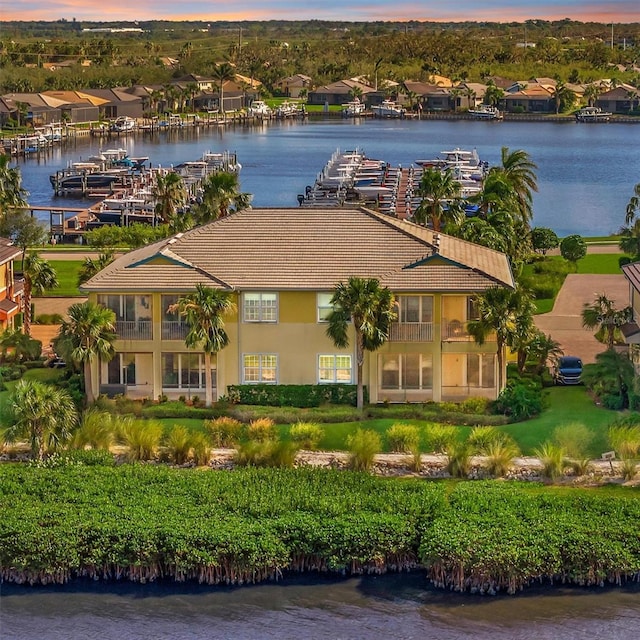 aerial view at dusk featuring a water view