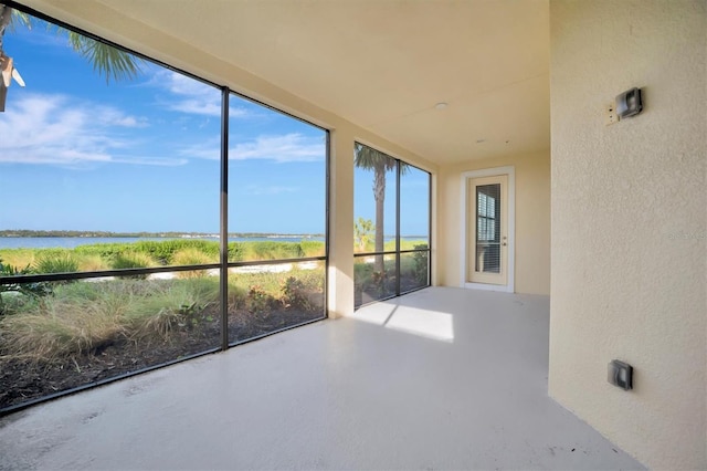 unfurnished sunroom with a water view