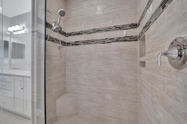 bathroom with vanity and a tile shower