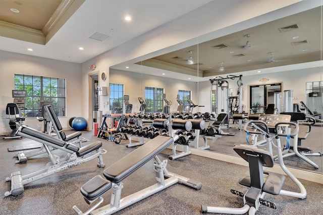 workout area featuring ceiling fan, a raised ceiling, and crown molding