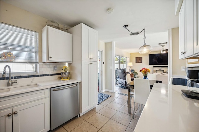 kitchen with hanging light fixtures, sink, decorative backsplash, white cabinets, and dishwasher