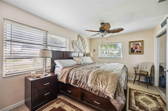 tiled bedroom featuring ceiling fan and a closet