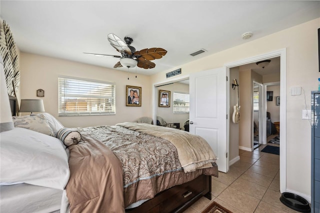 tiled bedroom with ceiling fan and a closet