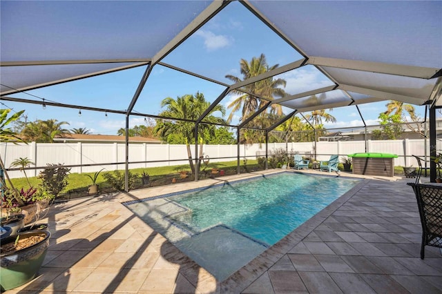 view of pool with glass enclosure and a patio