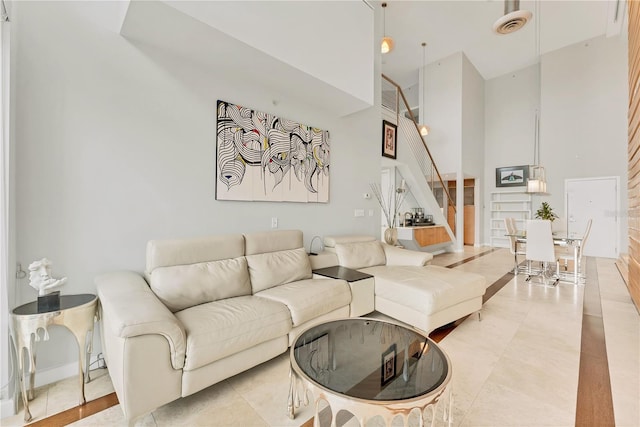 living room with a high ceiling and light tile patterned floors