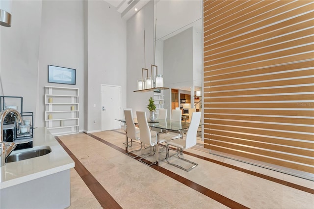 dining space featuring sink and a towering ceiling