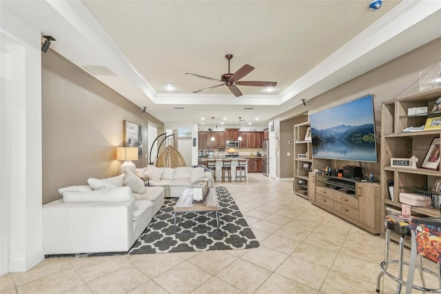 living room featuring light tile patterned floors, a raised ceiling, ceiling fan, and ornamental molding