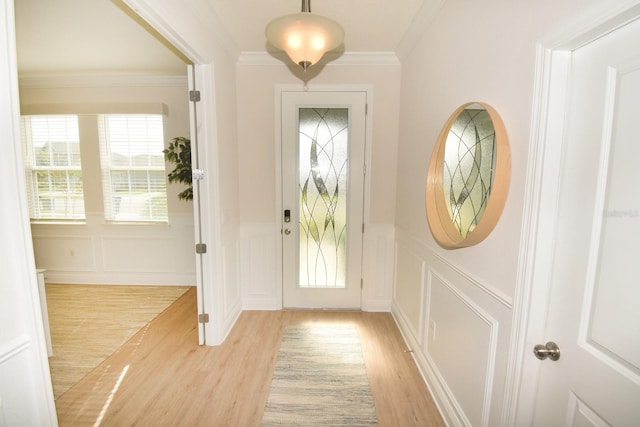 doorway with light hardwood / wood-style flooring and crown molding