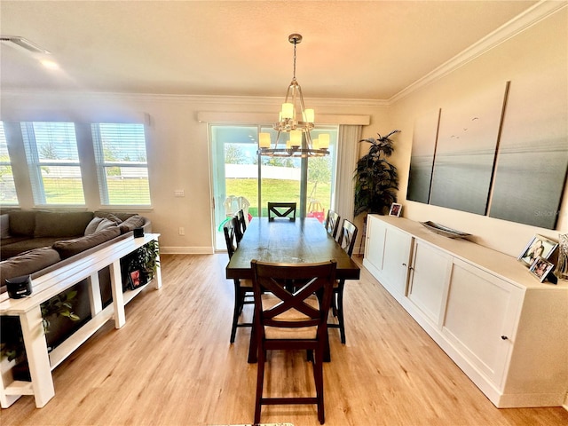 dining room with crown molding, light hardwood / wood-style flooring, and a chandelier