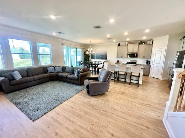 living room featuring light hardwood / wood-style floors, crown molding, and a healthy amount of sunlight