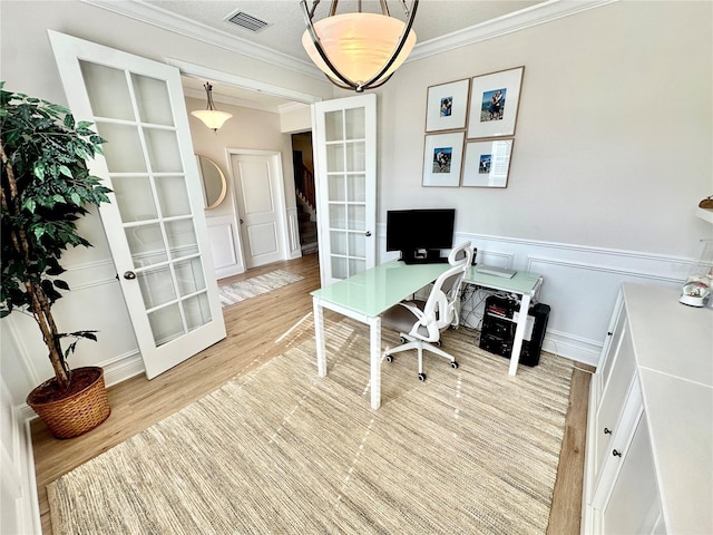 office space featuring crown molding, french doors, light hardwood / wood-style floors, and a textured ceiling