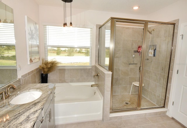 bathroom featuring tile patterned flooring, vanity, and shower with separate bathtub