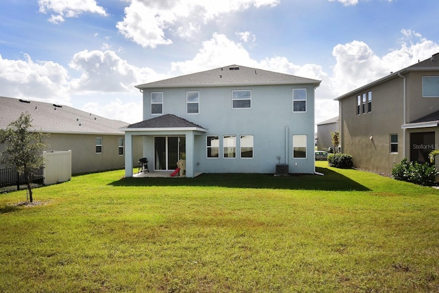 rear view of property featuring a yard, a patio, and central air condition unit