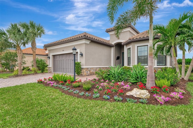 mediterranean / spanish-style house with a garage and a front lawn