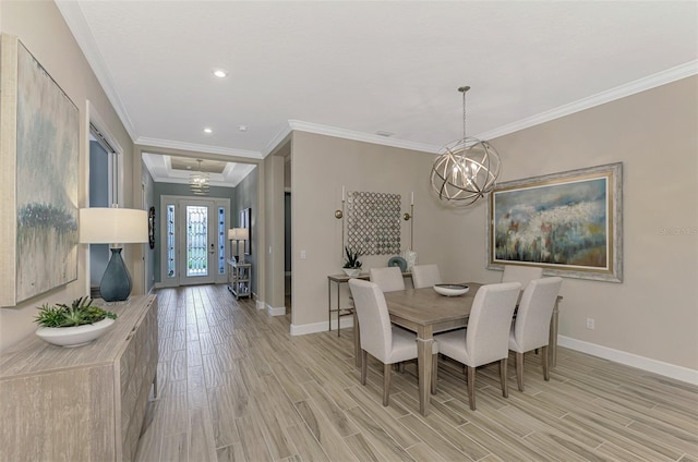 dining space featuring light wood-type flooring, a notable chandelier, and ornamental molding