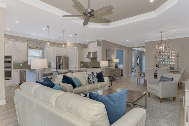 living room featuring ceiling fan with notable chandelier, light hardwood / wood-style flooring, and crown molding