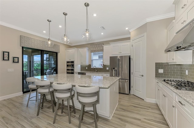 kitchen with a wealth of natural light, appliances with stainless steel finishes, and a center island