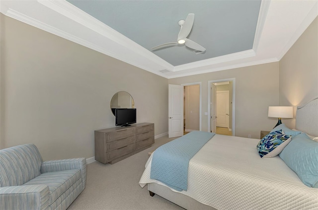 bedroom featuring ceiling fan, ornamental molding, light carpet, and a tray ceiling