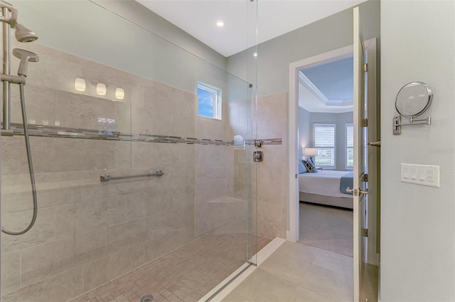 bathroom with plenty of natural light, tile patterned floors, tiled shower, and crown molding