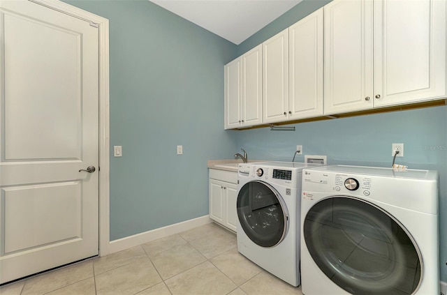 clothes washing area featuring cabinets, light tile patterned floors, sink, and washer and dryer