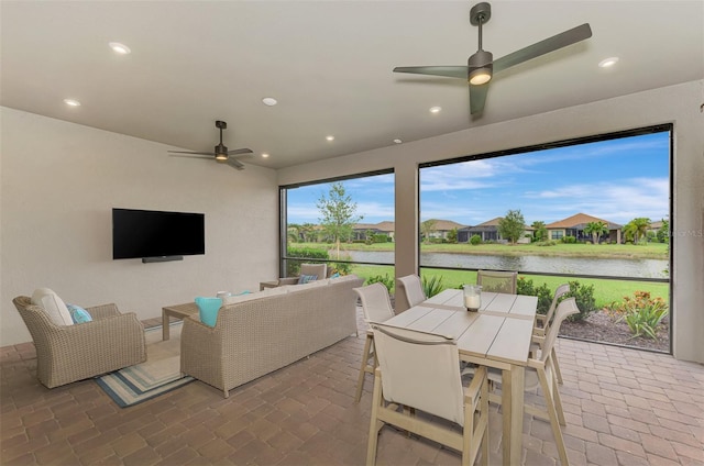 view of patio featuring a water view, ceiling fan, and an outdoor living space