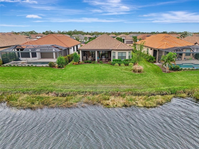 view of front of home with a front lawn, a patio, a swimming pool with hot tub, a water view, and a lanai