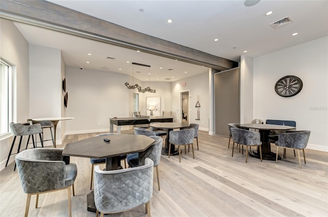 dining area featuring beam ceiling and light hardwood / wood-style flooring