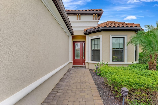 entrance to property with stucco siding and a tile roof