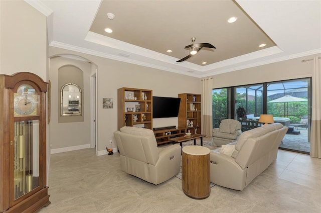 living room featuring crown molding, ceiling fan, and a raised ceiling