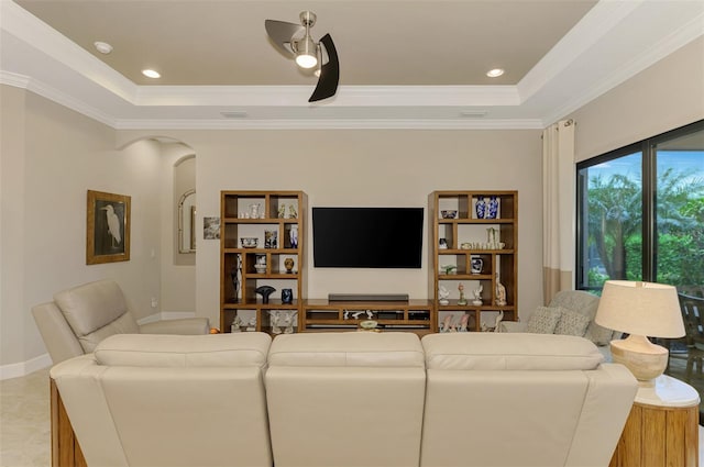 living room featuring light tile patterned floors, a raised ceiling, and ornamental molding