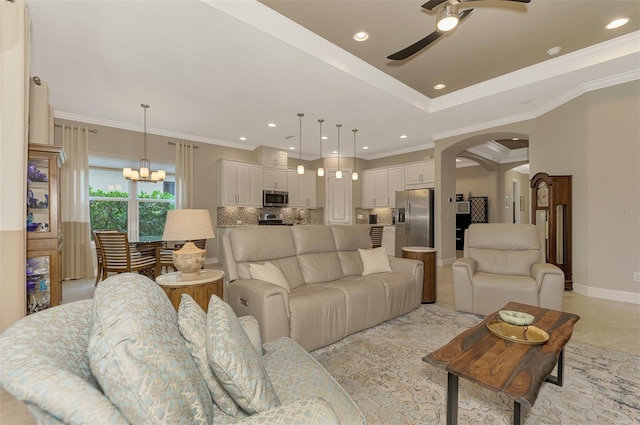 living room with ornamental molding and ceiling fan with notable chandelier