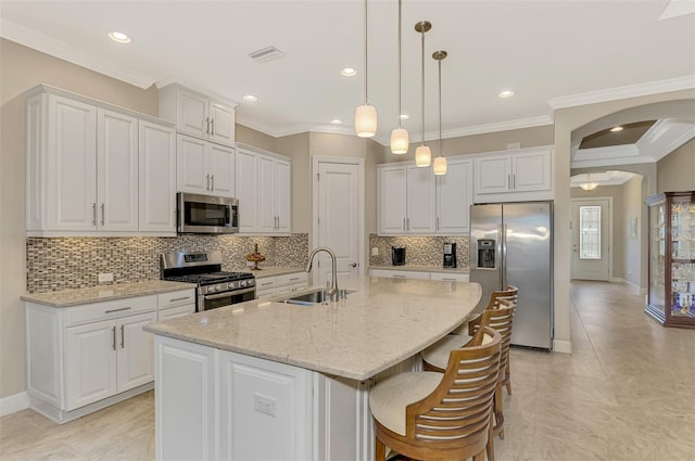 kitchen with white cabinetry, a center island with sink, stainless steel appliances, and sink