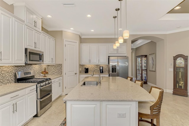 kitchen featuring stainless steel appliances, white cabinetry, sink, a kitchen island with sink, and pendant lighting