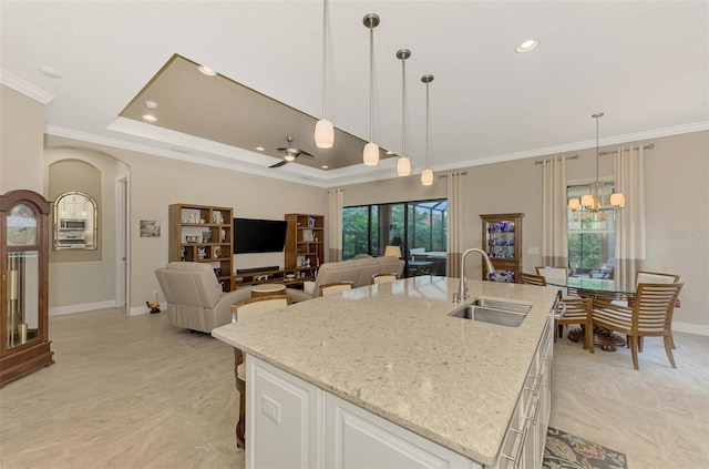 kitchen with white cabinets, a center island with sink, plenty of natural light, and sink