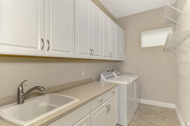 laundry room with cabinets, sink, and washer and dryer