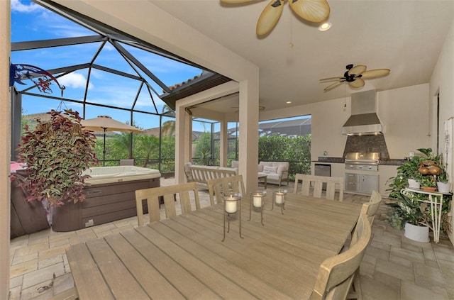 deck with a hot tub, grilling area, ceiling fan, area for grilling, and a lanai