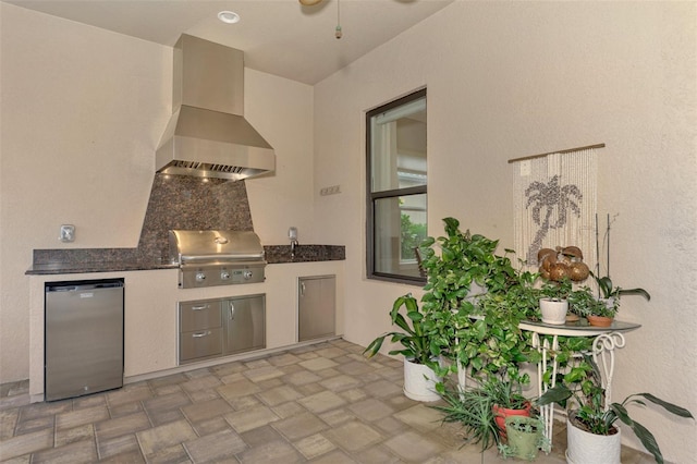 kitchen featuring fridge, wall chimney exhaust hood, and backsplash