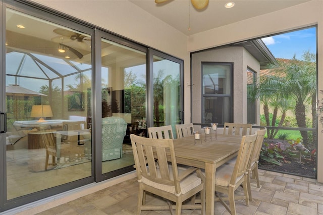 sunroom / solarium featuring a ceiling fan and outdoor dining space